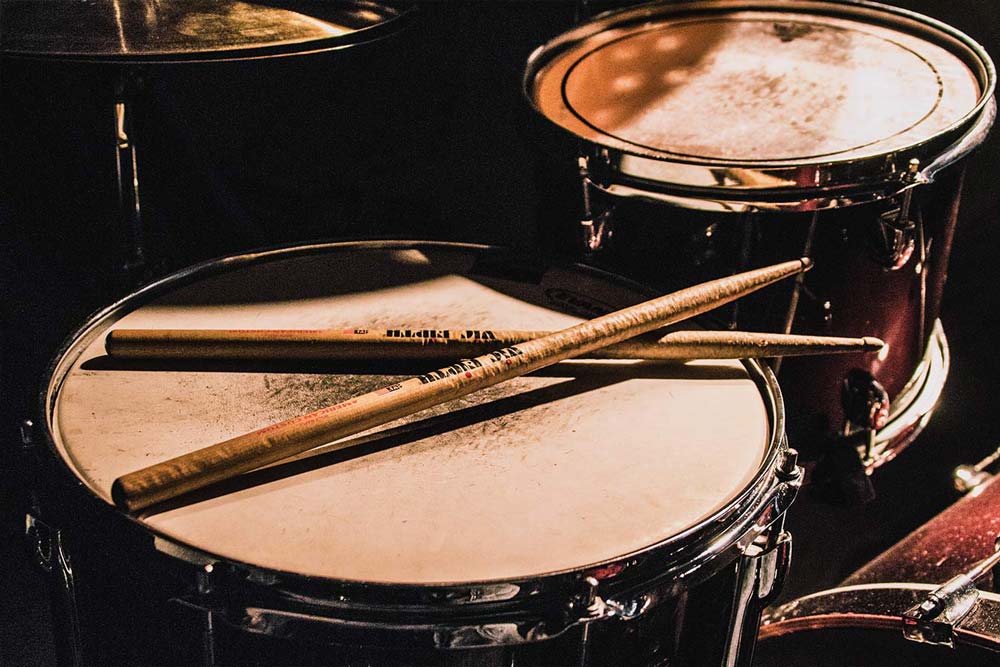 A snare drum with a pair of drum sticks
